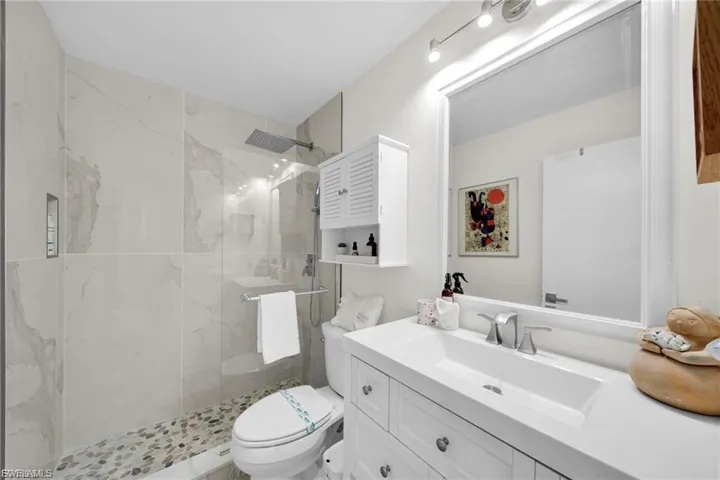 Contemporary bathroom featuring a walk-in shower with stone tile flooring and large format wall tiles