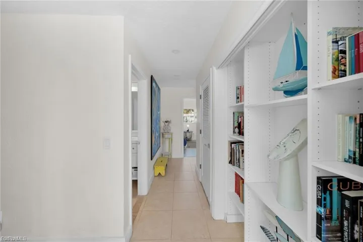 Hallway featuring built-in shelving, recessed lighting, tile flooring, and light-colored walls