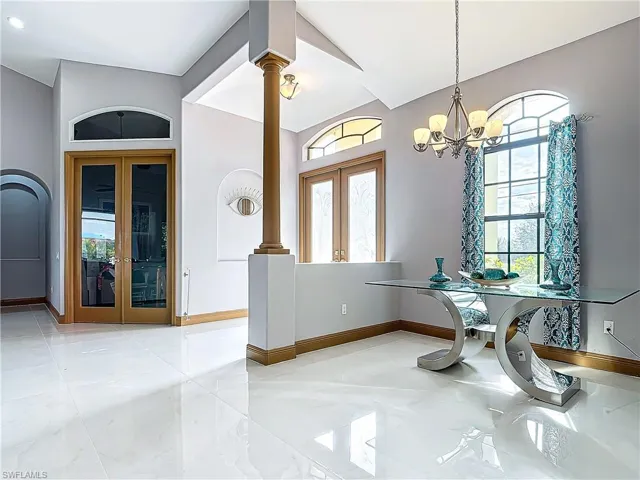 Dining room with french doors, a chandelier, and lofted ceiling