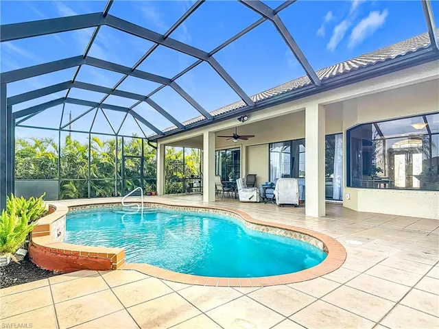 View of pool with a lanai, a patio area, and ceiling fan