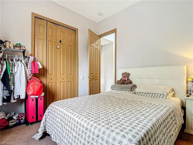 Carpeted bedroom with a closet