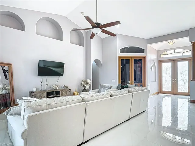 Living room featuring french doors, vaulted ceiling, and ceiling fan