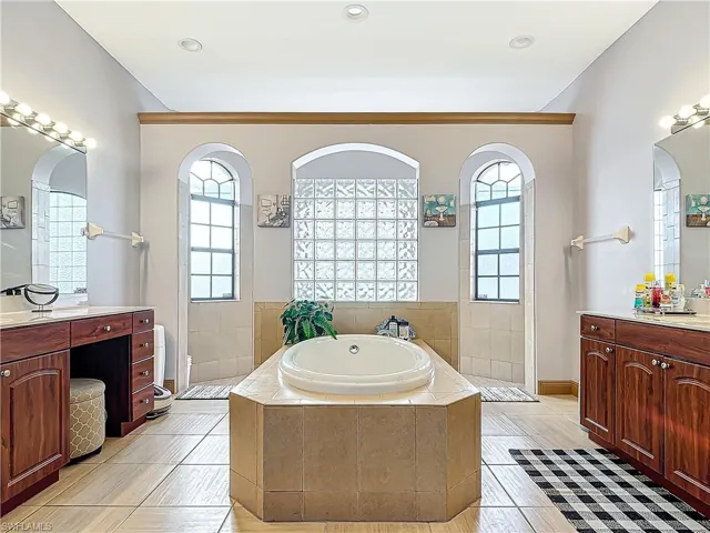 Bathroom featuring tile patterned flooring, vanity, and independent shower and bath