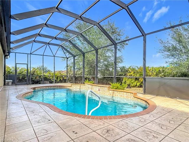View of swimming pool featuring a patio area and a lanai