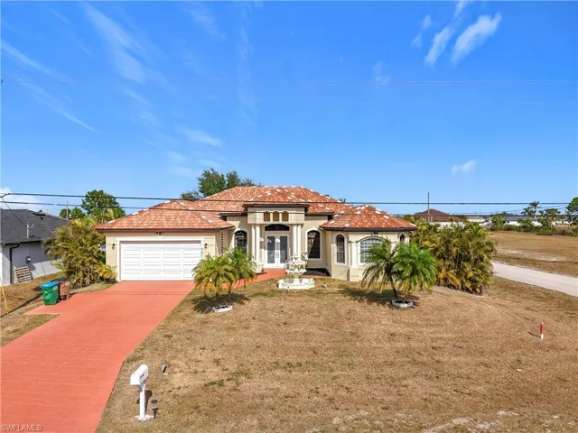 View of front of house featuring a garage and a front lawn