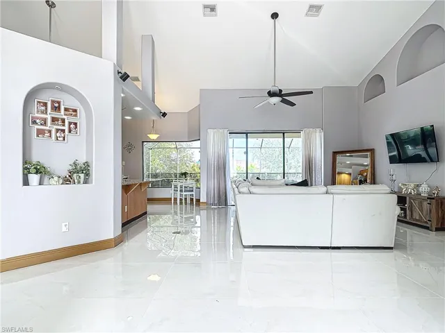 Living room featuring a high ceiling and ceiling fan