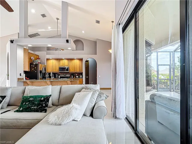 Living room featuring beam ceiling, high vaulted ceiling, and ceiling fan