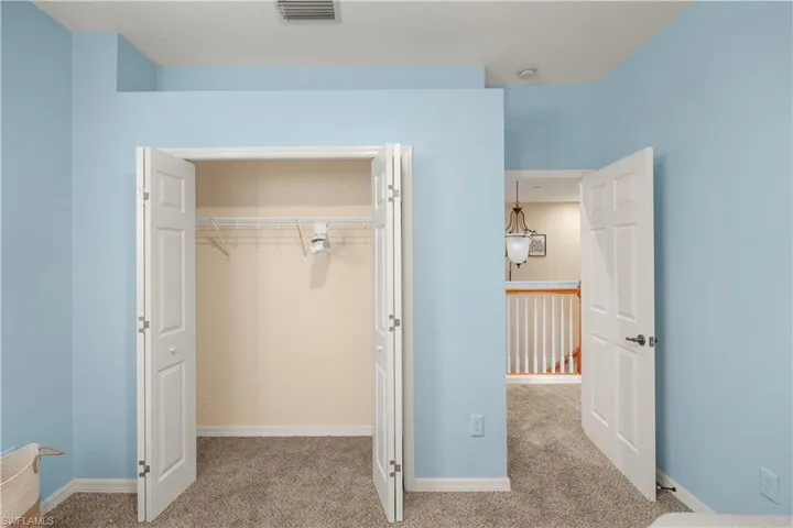 Unfurnished bedroom featuring light carpet and a closet