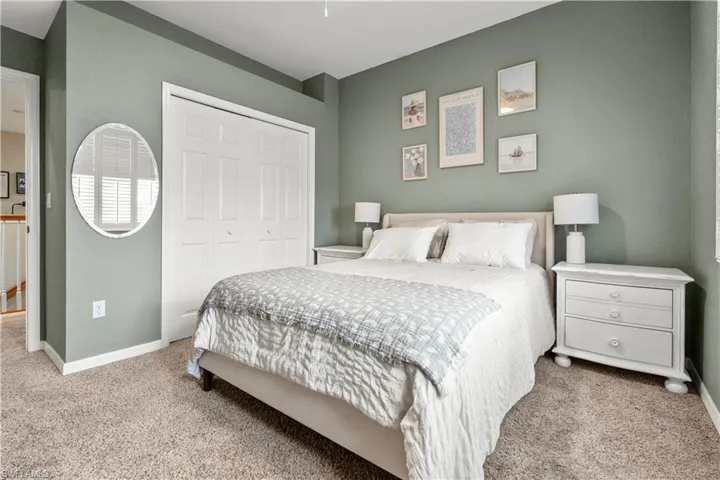 Carpeted bedroom with a closet and a ceiling fan