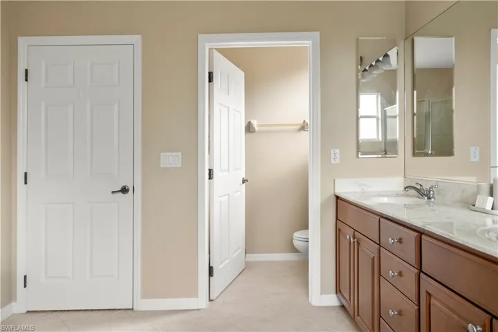 Bathroom with double vanity and light tile patterned floors