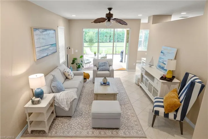 Living area featuring light tile patterned floors and a ceiling fan