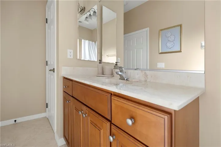 Bathroom with vanity, light tile patterned floors, and curtained shower