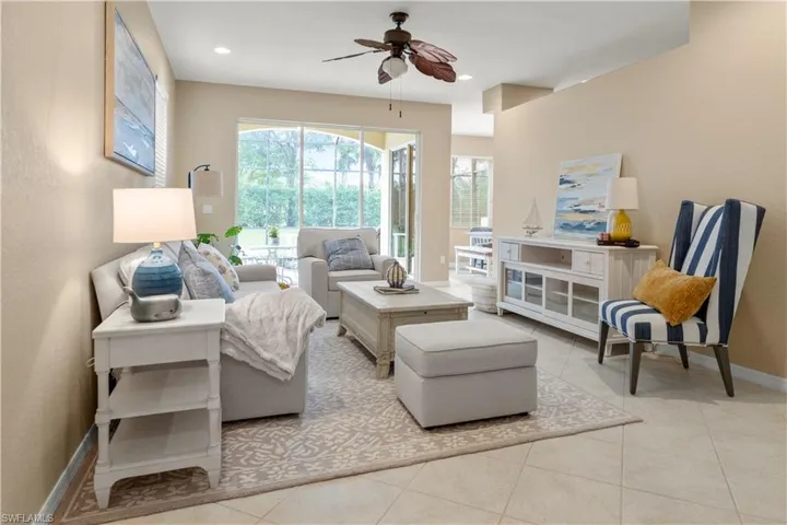 Living area with a ceiling fan, light tile patterned flooring, and recessed lighting