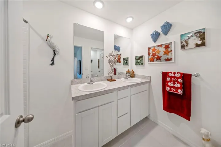 Full bathroom with double vanity and light tile patterned flooring