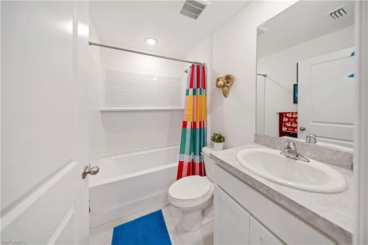 Full bath featuring shower / bath combo, vanity, and tile patterned flooring