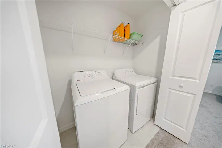 Laundry room featuring washing machine and dryer and baseboards