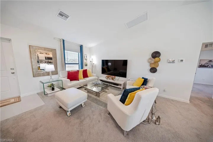 Living area featuring light carpet and high vaulted ceiling