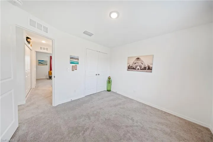 Unfurnished bedroom with light carpet and a closet