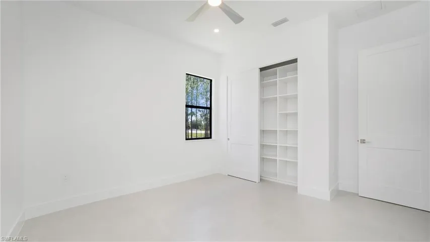 Bright interior space featuring a window with black trim, recessed lighting, and a ceiling fan