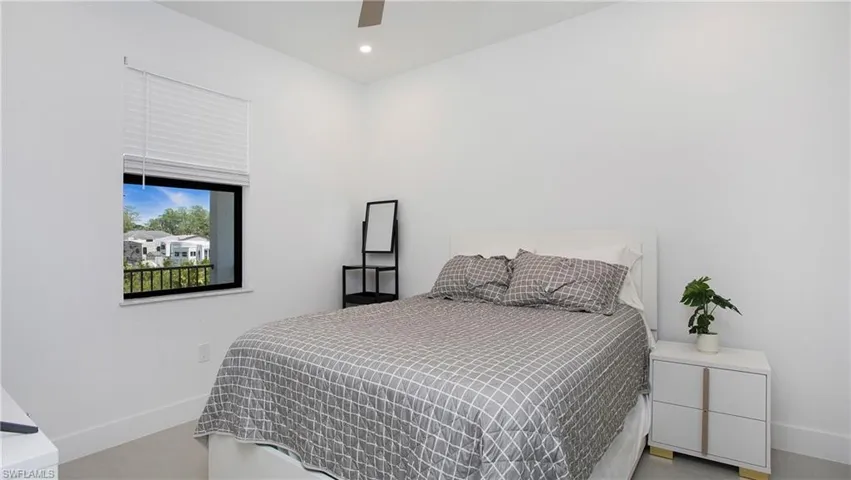 Bright room featuring a single window with blinds and dark framing