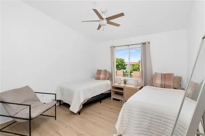 Bedroom with lofted ceiling, light wood finished floors, and a ceiling fan