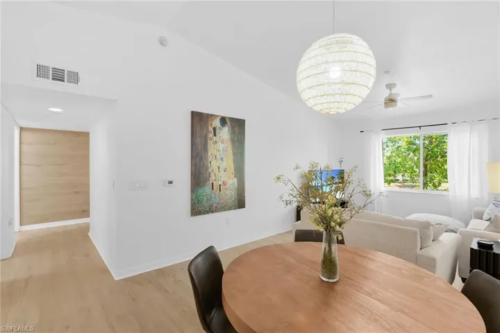 Dining area featuring light wood finished floors, baseboards, ceiling fan, and lofted ceiling