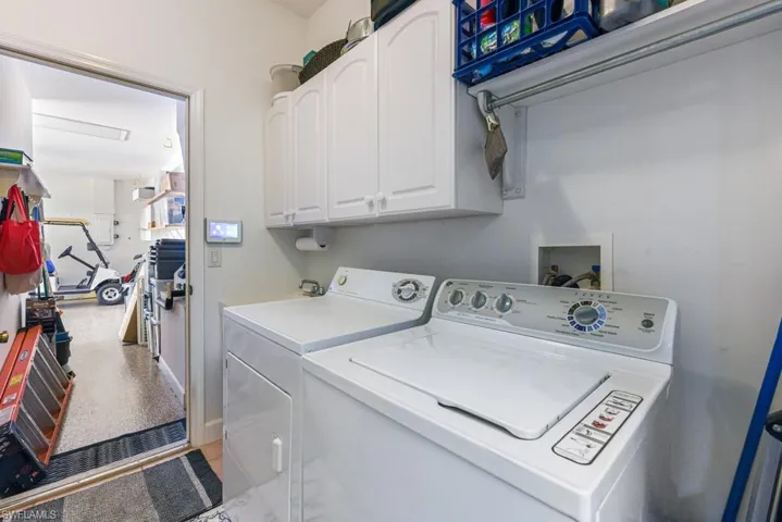 Laundry area featuring cabinets and washing machine and dryer