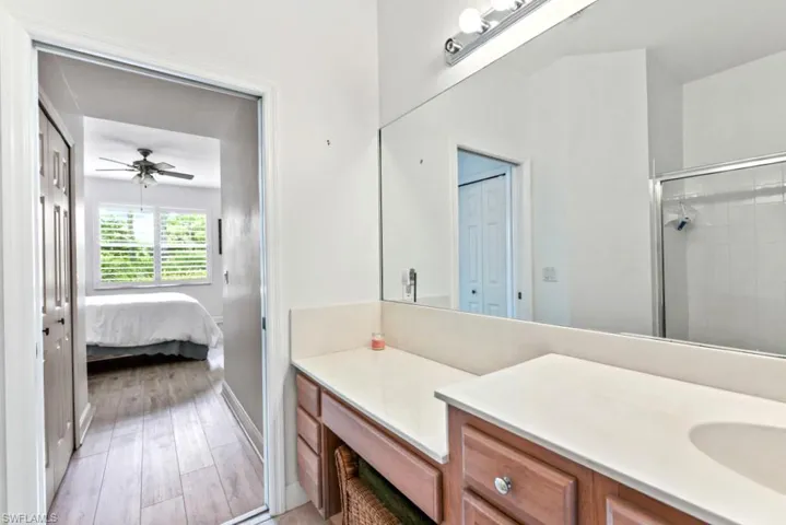 Bathroom featuring vanity, hardwood / wood-style flooring, ceiling fan, and walk in shower
