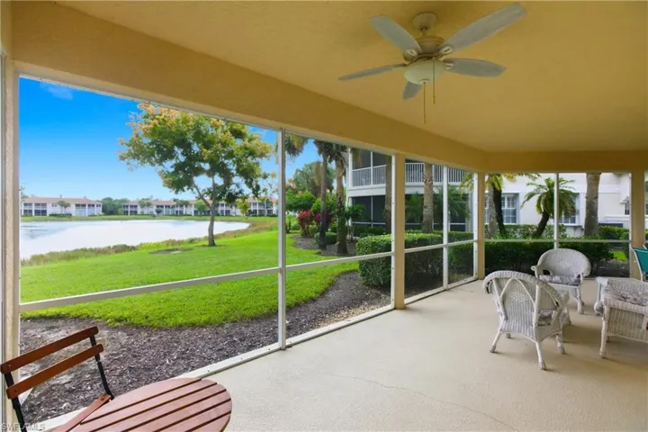 Unfurnished sunroom featuring a water view, ceiling fan, and a patio area