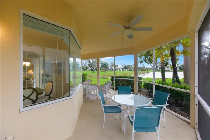 Sunroom / solarium with ceiling fan, outdoor dining space, a water view, and a patio