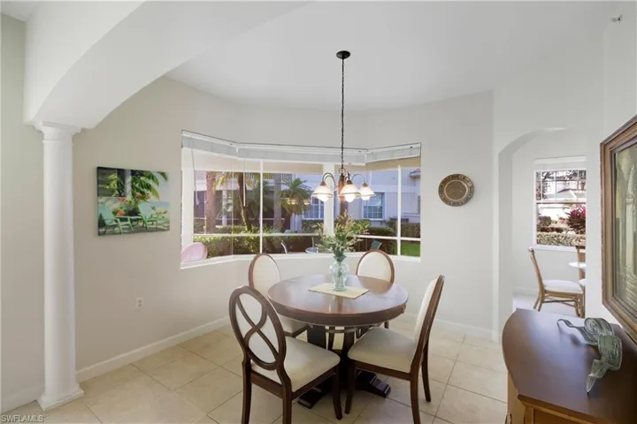 Dining area featuring arched walkways and light tile patterned flooring