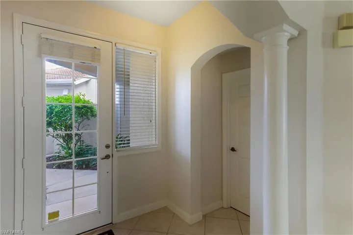 Doorway to outside with tile patterned floors and arched walkways