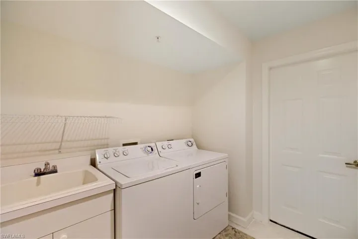 Laundry room featuring light tile patterned floors and washing machine and dryer