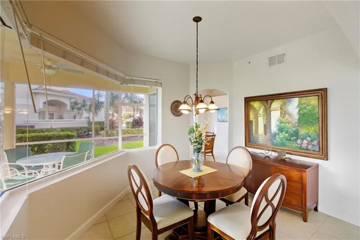 Dining room with light tile patterned floors, a ceiling fan, and a chandelier