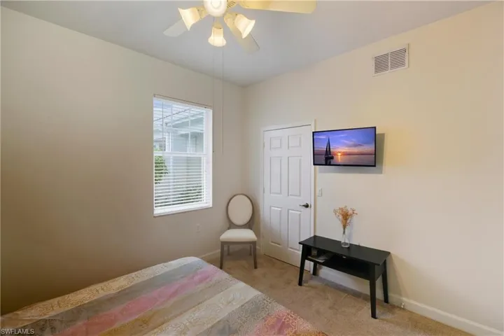 Bedroom with light colored carpet and ceiling fan