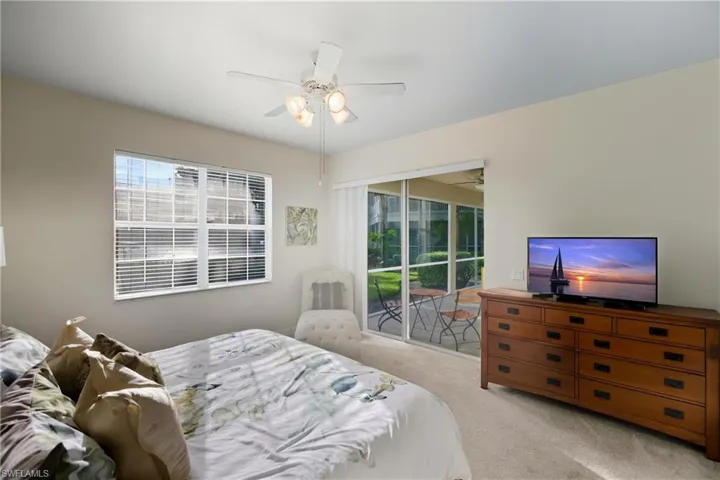 Carpeted bedroom featuring access to outside and a ceiling fan
