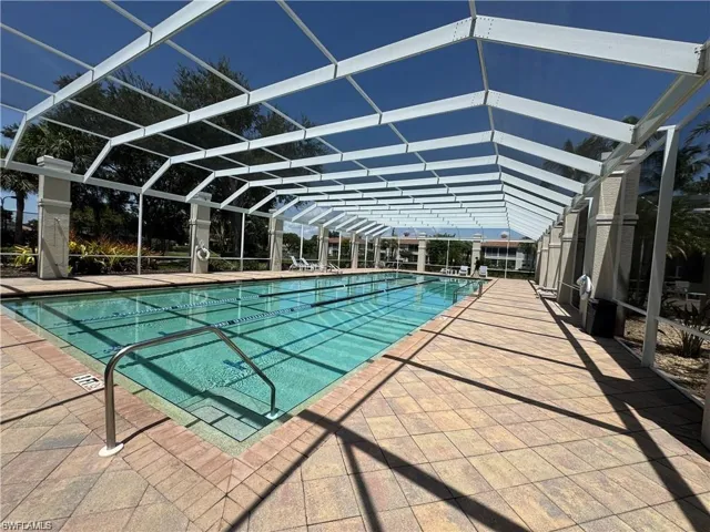 Community pool featuring glass enclosure and a patio area
