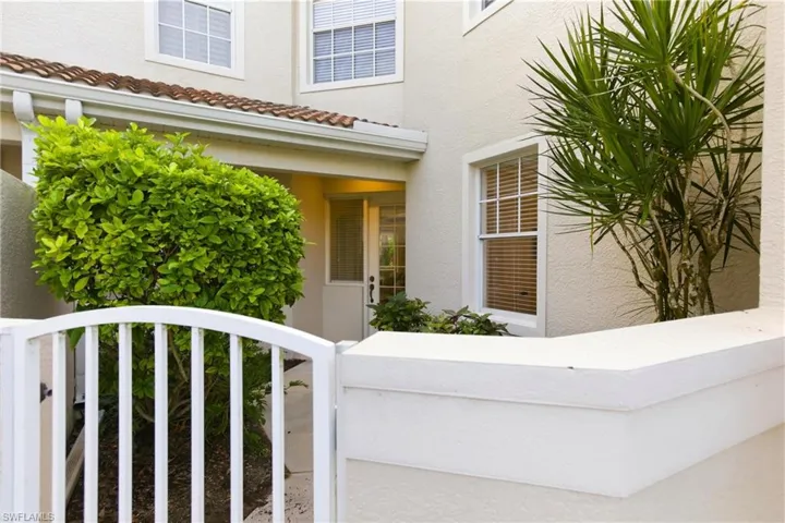 Doorway to property featuring stucco siding, a tile roof, and a gate