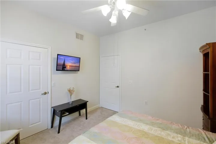 Bedroom with light carpet and a ceiling fan