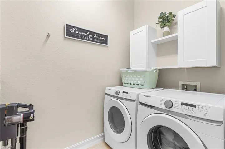 Washroom featuring separate washer and dryer and cabinets