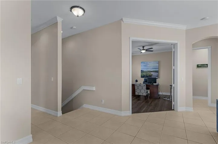 Hall with crown molding and light tile patterned floors