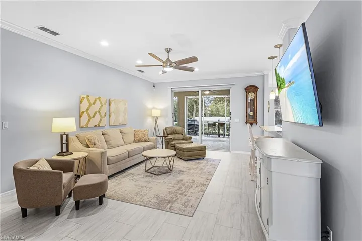 Living room featuring ornamental molding and a ceiling fan