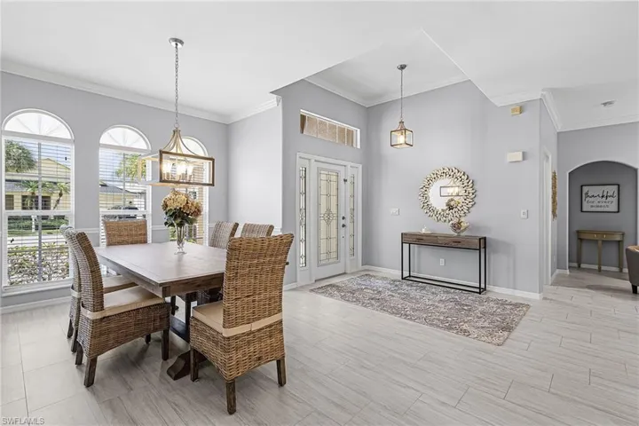Dining space featuring ornamental molding and arched walkways