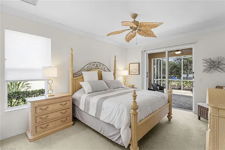 Bedroom featuring light colored carpet, ornamental molding, a ceiling fan, and access to exterior