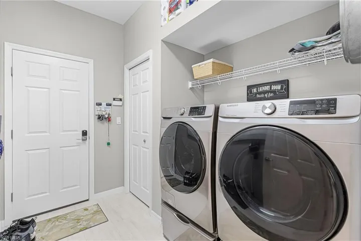 Laundry area with washing machine and clothes dryer and baseboards