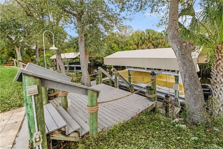 Dock area featuring boat lift and a water view