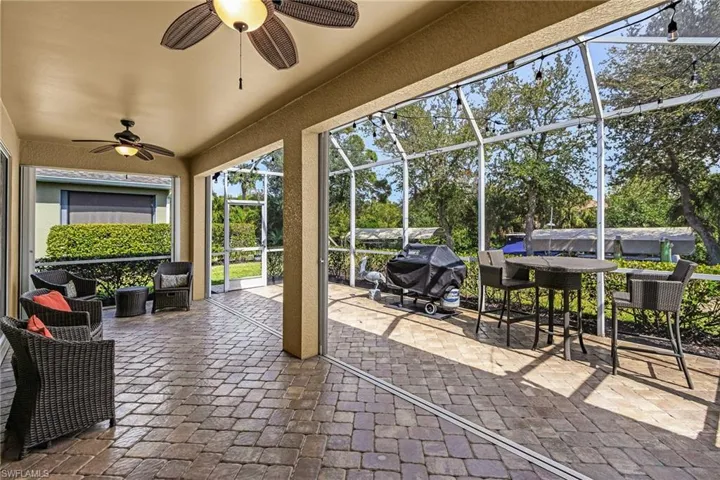 View of patio / terrace featuring a lanai, a sunroom, ceiling fan, and a grill