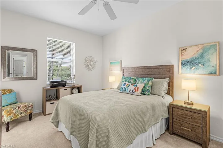 Bedroom with light colored carpet and a ceiling fan
