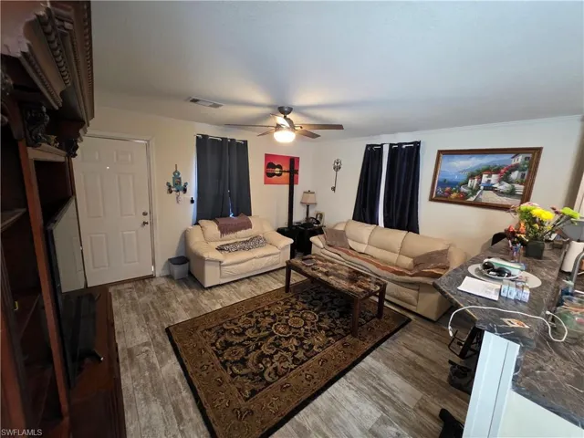 Living area featuring wood finished floors and ceiling fan