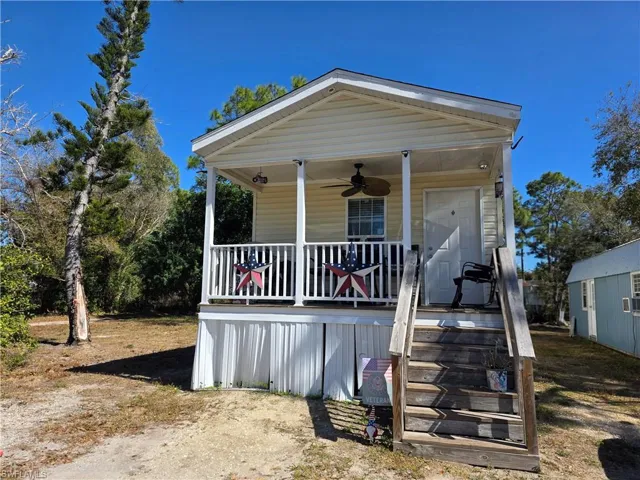 View of front of property with a ceiling fan and a porch